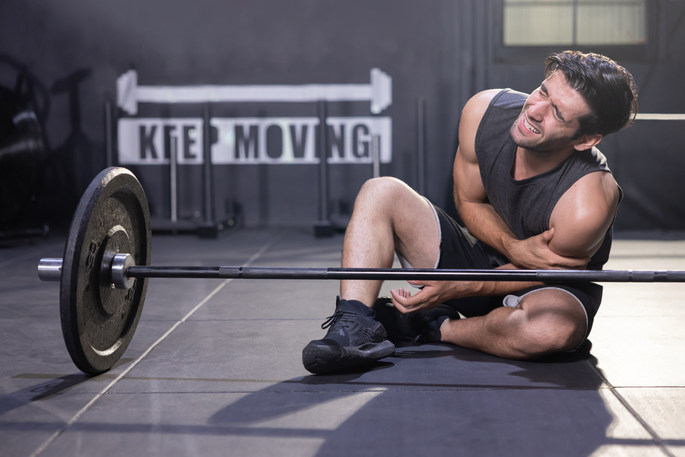 Trainer demonstrating proper workout techniques to prevent injuries